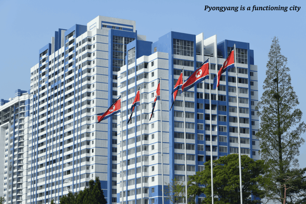 Flags blowing outside skyscrapers in Pyongyang, North Korea. -things you wouldn't expect about North Korea