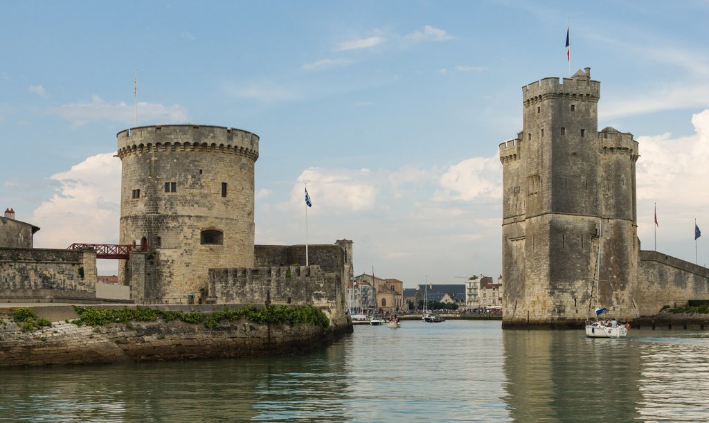 This image has an empty alt attribute; its file name is 1810px-Entrance_La_Rochelle_old_harbor-1024x611.jpg