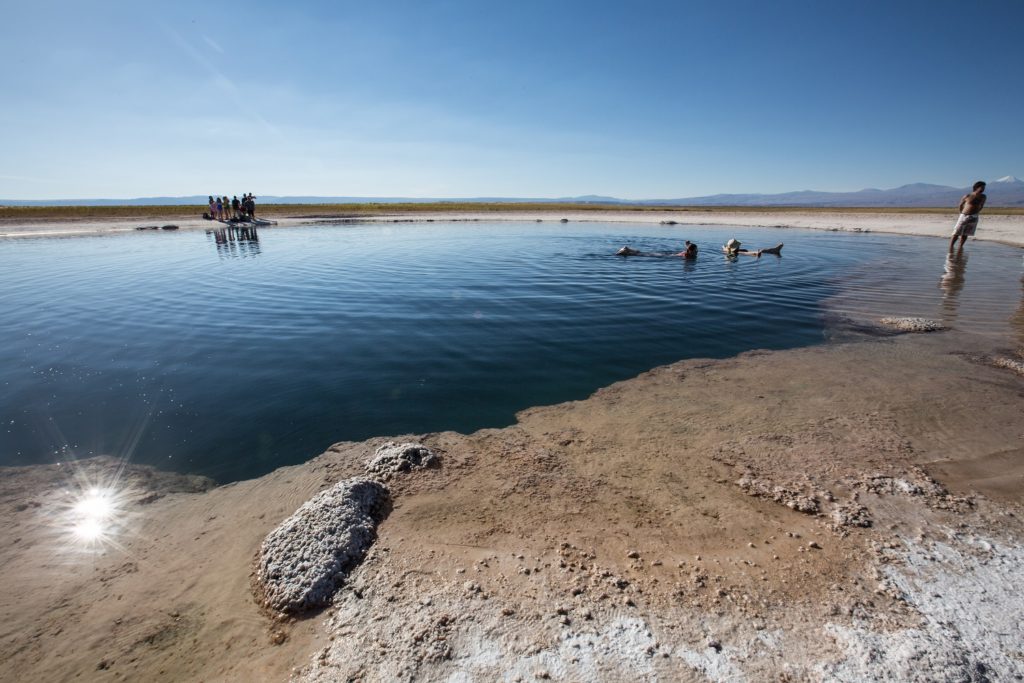 Swimming in the natural pool Salar de Uyuni Atacama Desert Chile by Nori Jemil