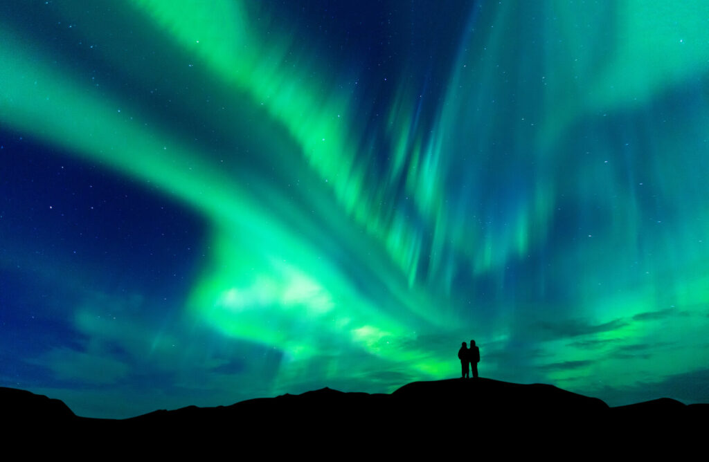Two people ahead of the Northern Lights