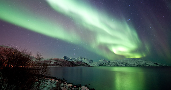 The northern lights shine over Norway's coastal areas.