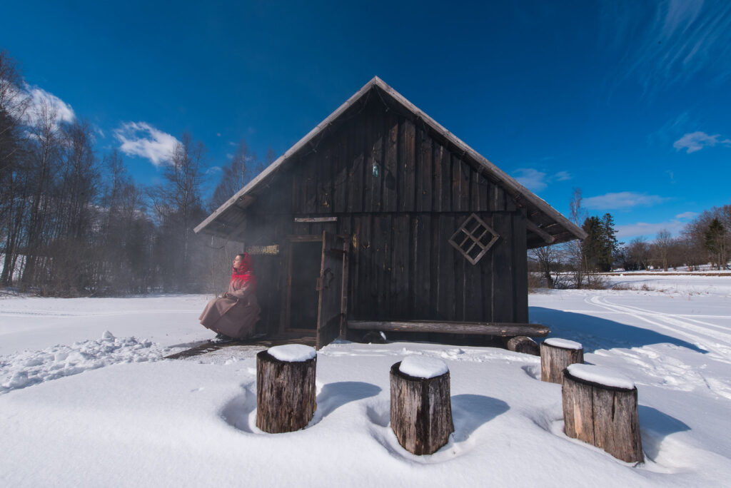 A traditional wooden smoke sauna stands in the snow in Estonia.