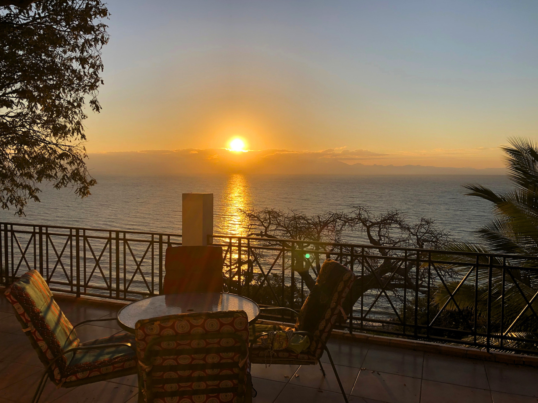 The sun setting on Lake Malawi in front of a patio