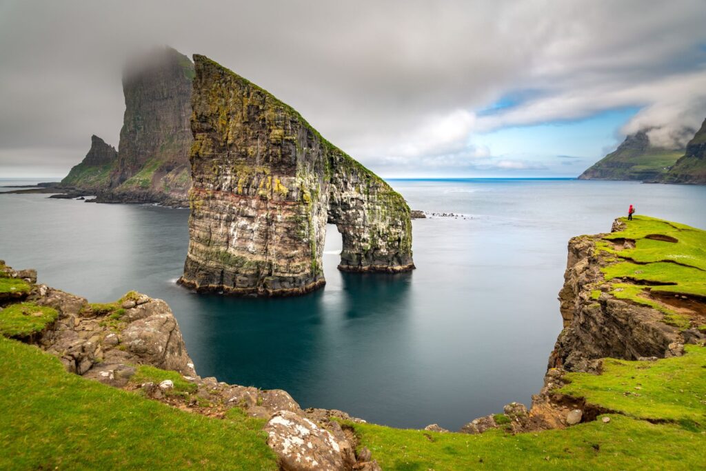 Hiker overlooking the Drandanir Rocks, Faroe Islands