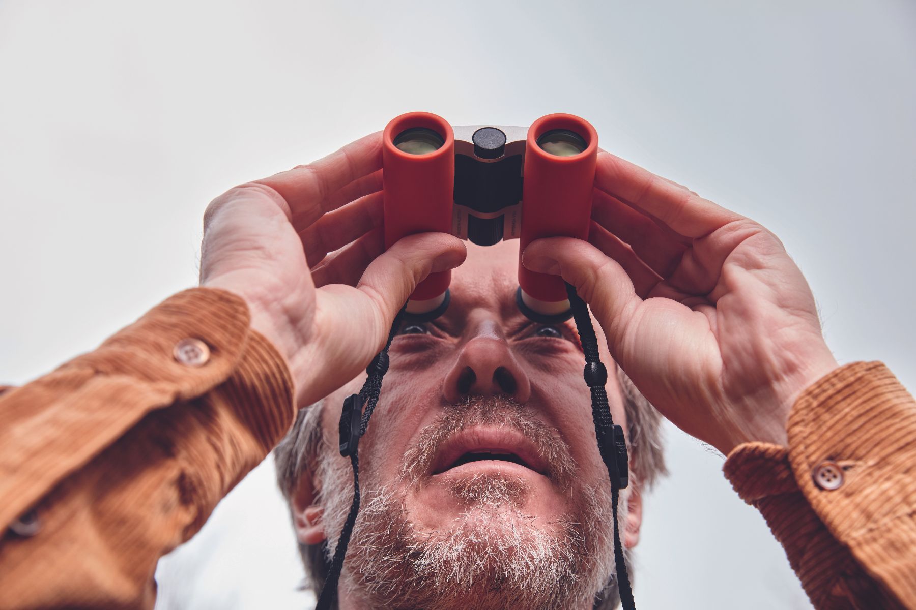 A man looking through a pair of binoculars.