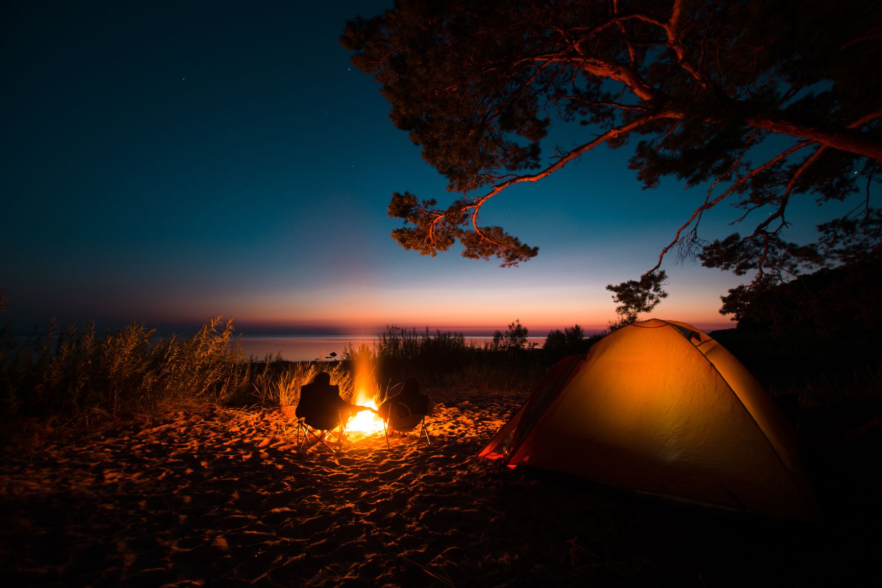 Campers enjoying a fire on a beach in Estonia