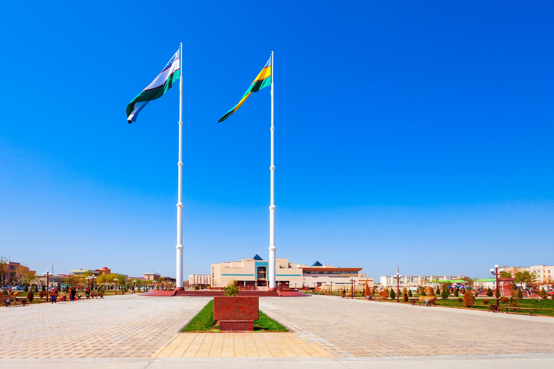 The national flag of Uzbekistan flying side-by-side with the regional flag of Karakalpakstan outside the Nukus Art Museum, Karakalpakstan