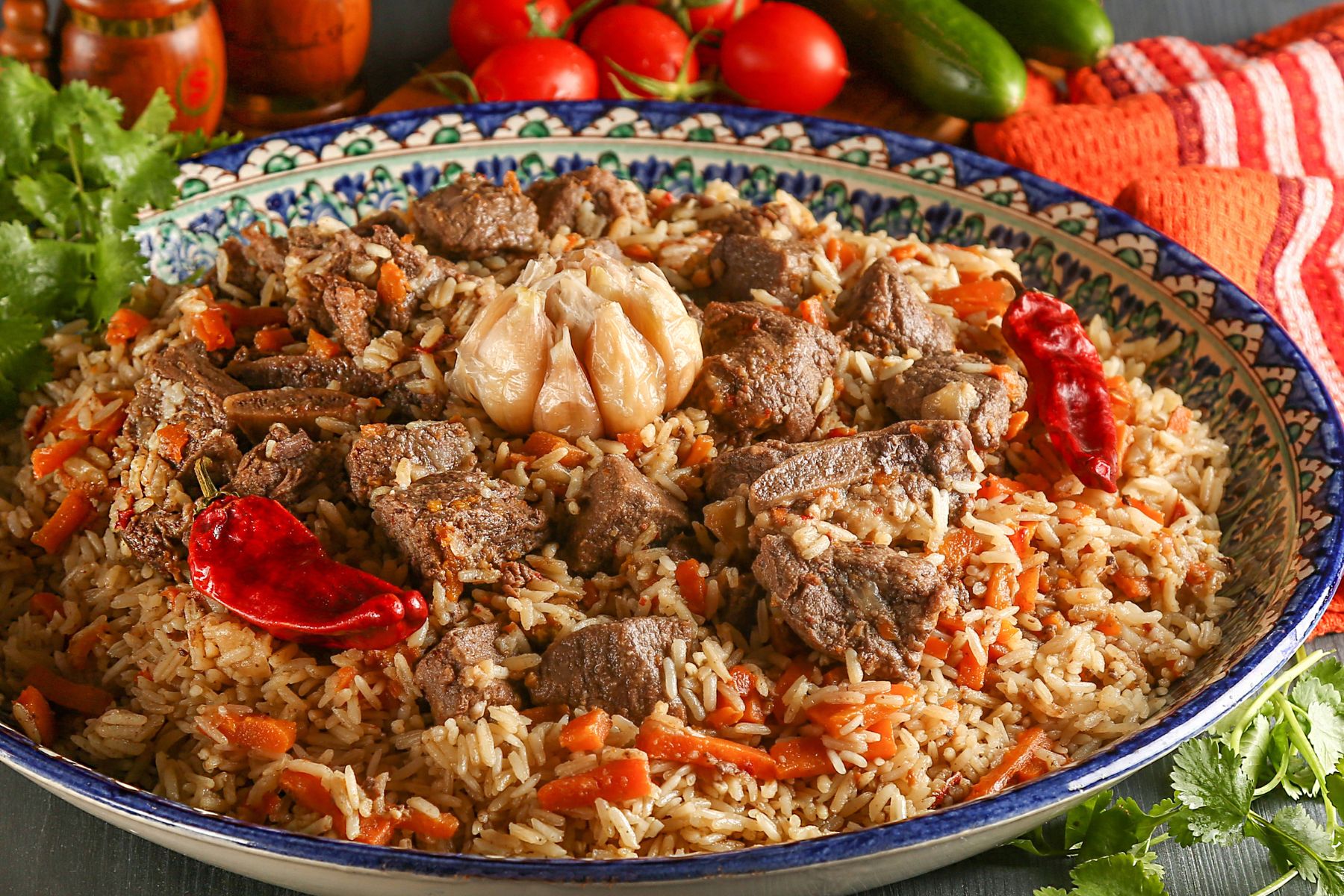 Uzbek pilaf or plov in authentic Uzbek plate on a wooden gray background