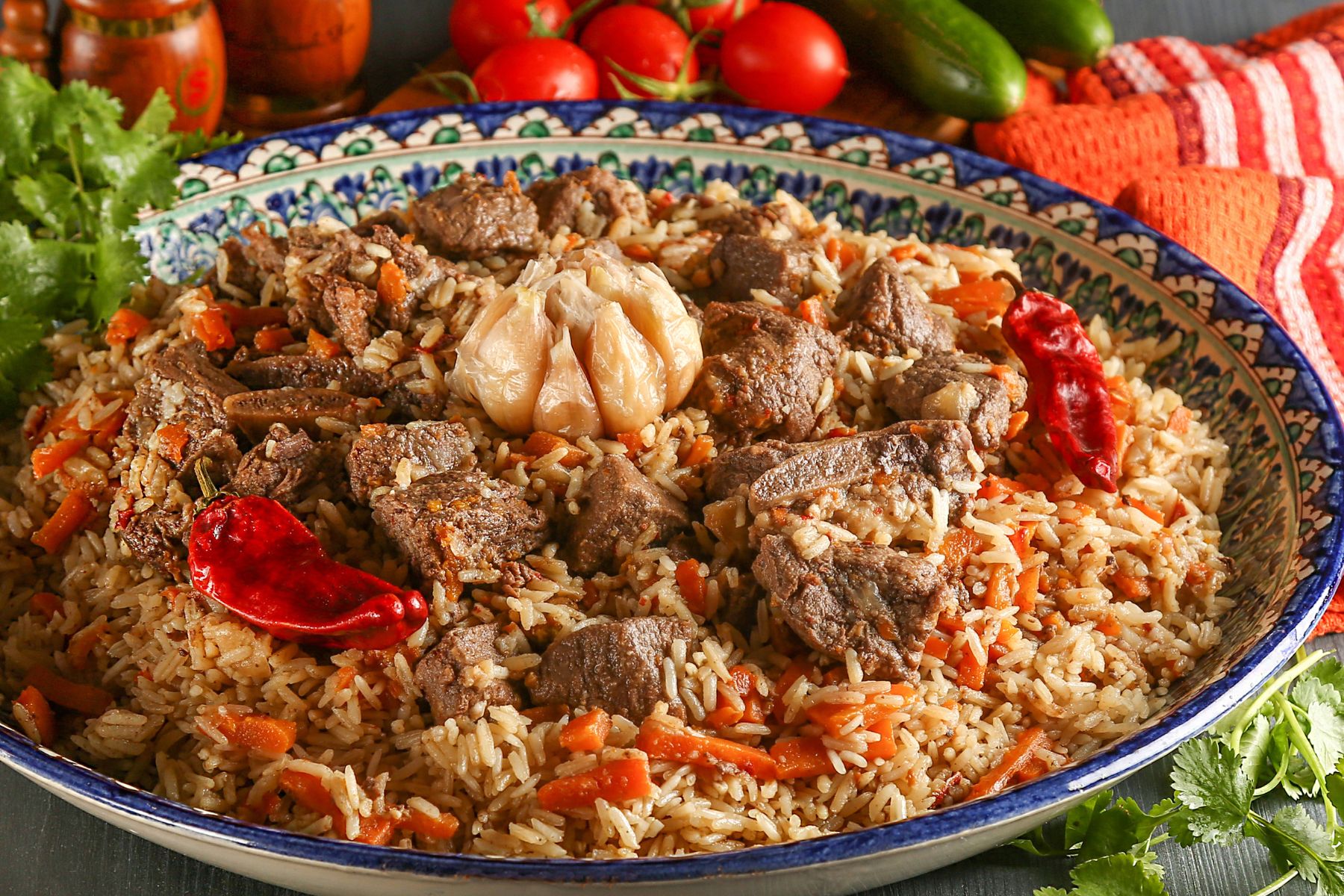 Uzbek pilaf or plov in authentic Uzbek plate on a wooden gray background