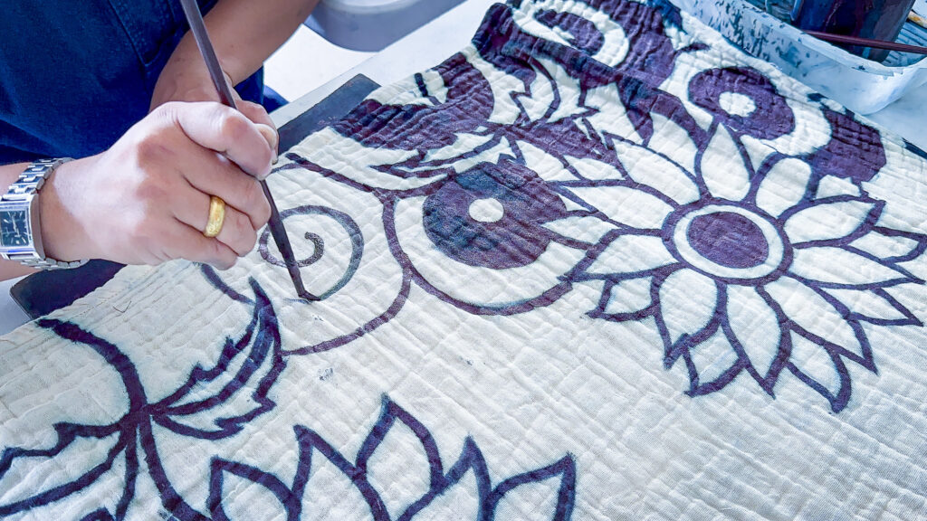 A woman paints with indigo in Phrae