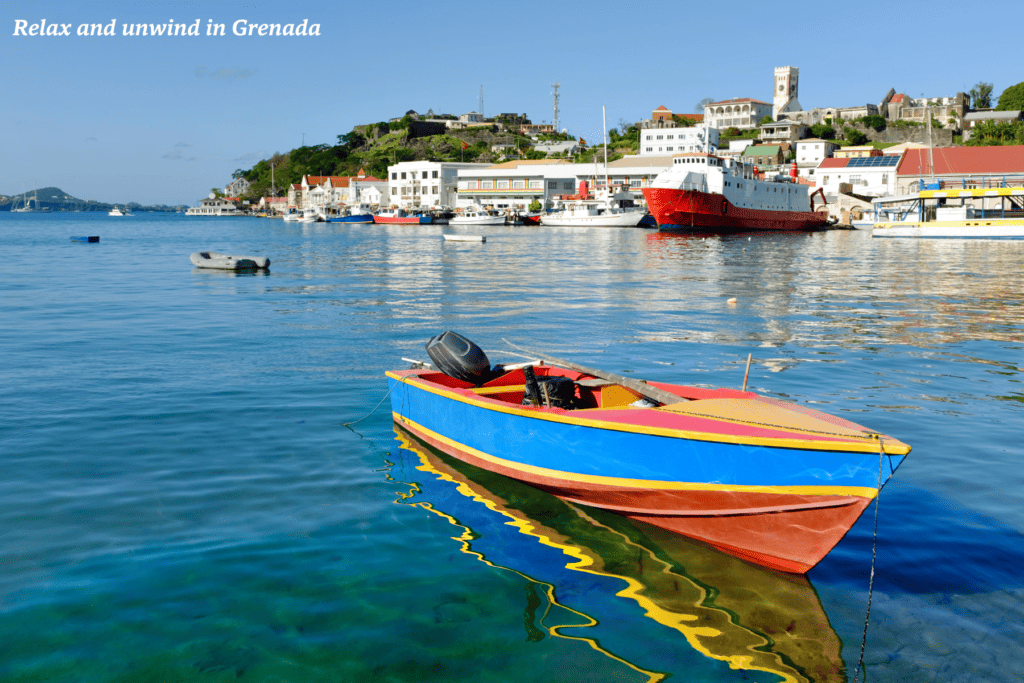 A colourful boat floats on clear blue water in Grenada 
