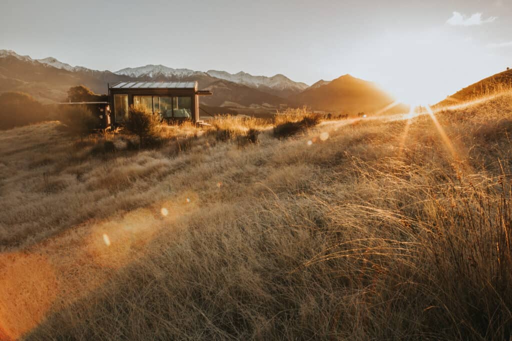 Small hut surrounded by nature in New Zealand at sunset 
