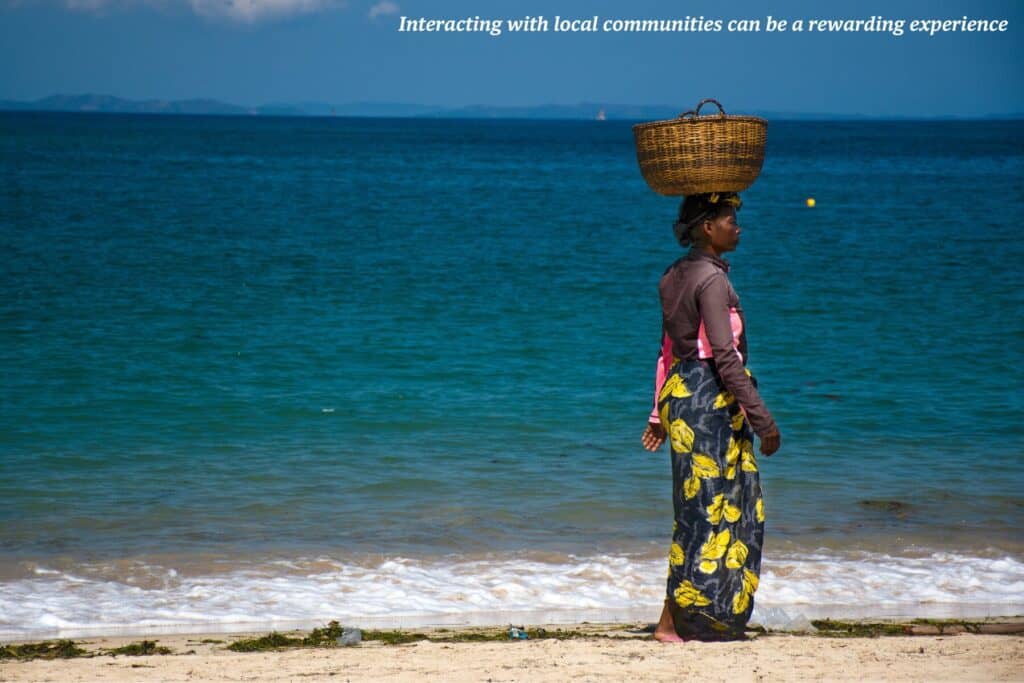A woman walks on the beach in Madagascar with a basket balanced on her head