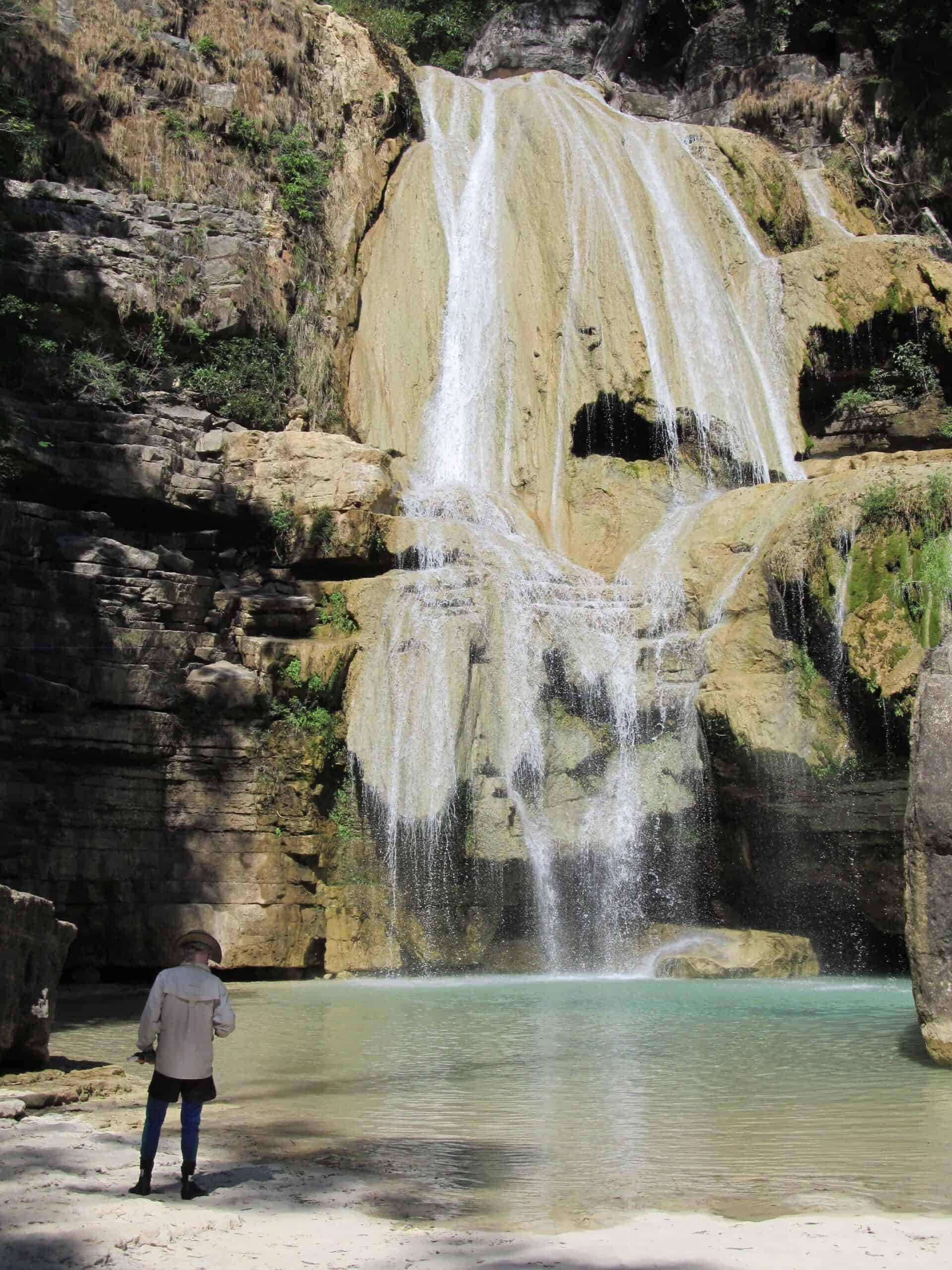 Man at the base of Tsiribihina River waterfall in Madagascar 