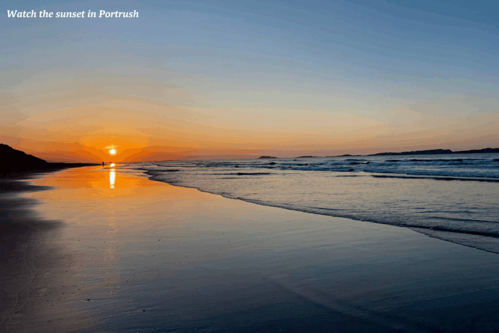 Sun setting over the sea on a beach in Portrush - where to go in Northern Ireland