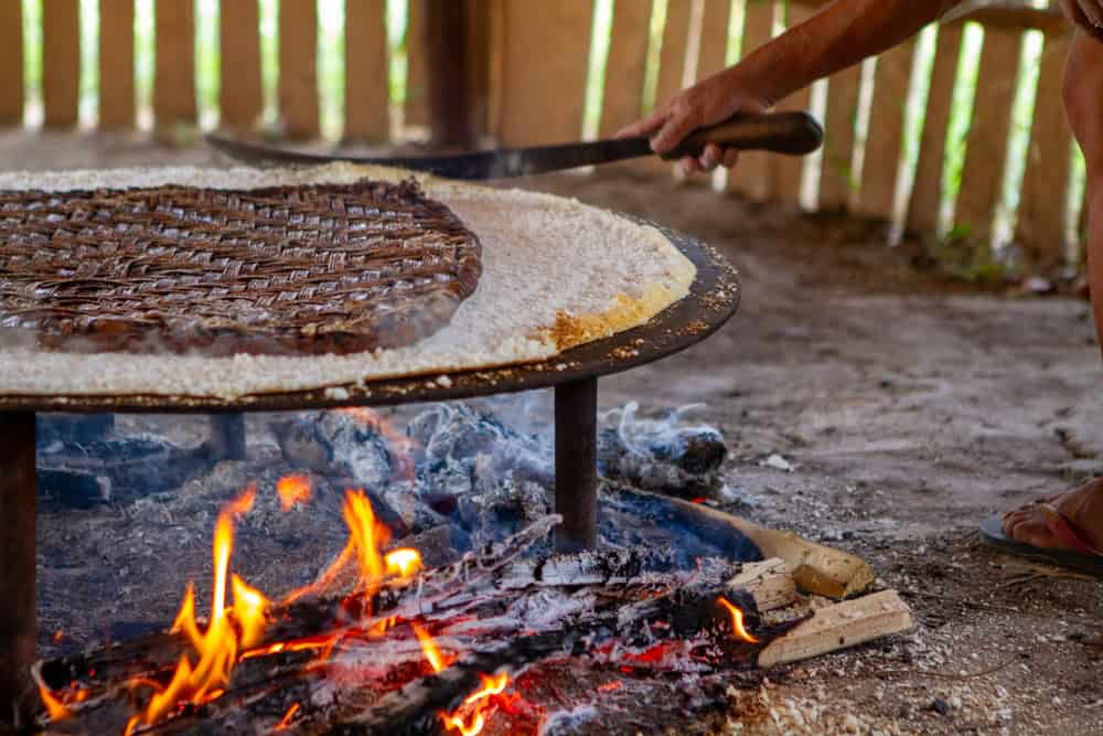 Woman cooking cassava bread over an open fire in Suriname
