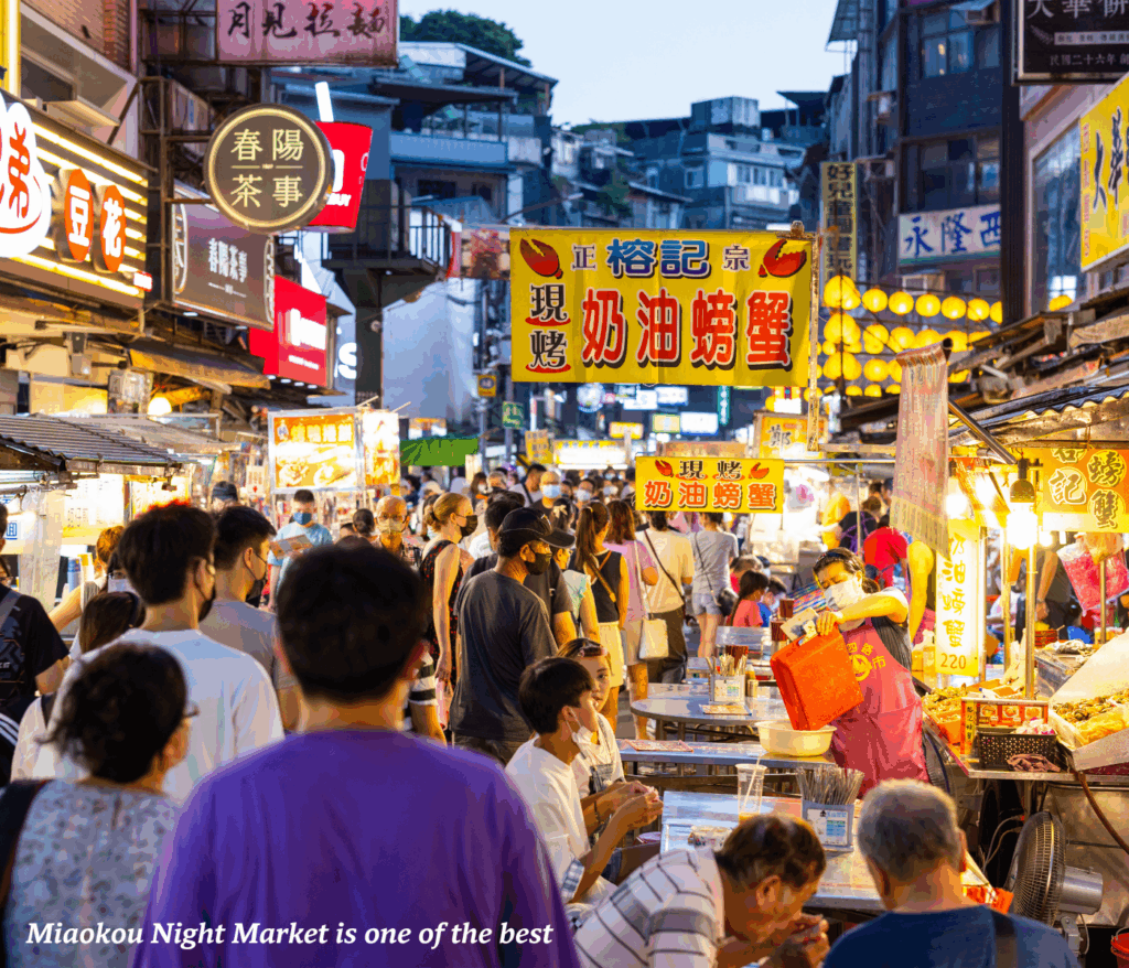 People walking through the Miaokou night market in Keelung, Taiwan
