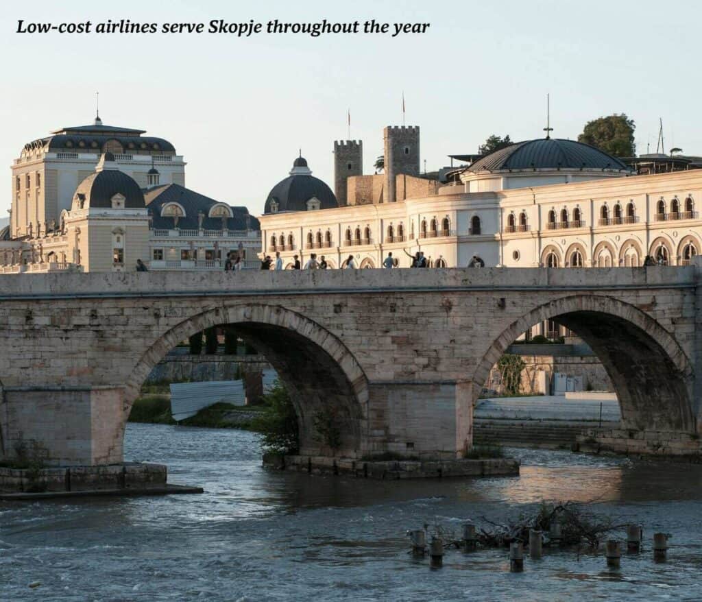 People walking over a traditional stone bridge in Skopje, North Macedonia