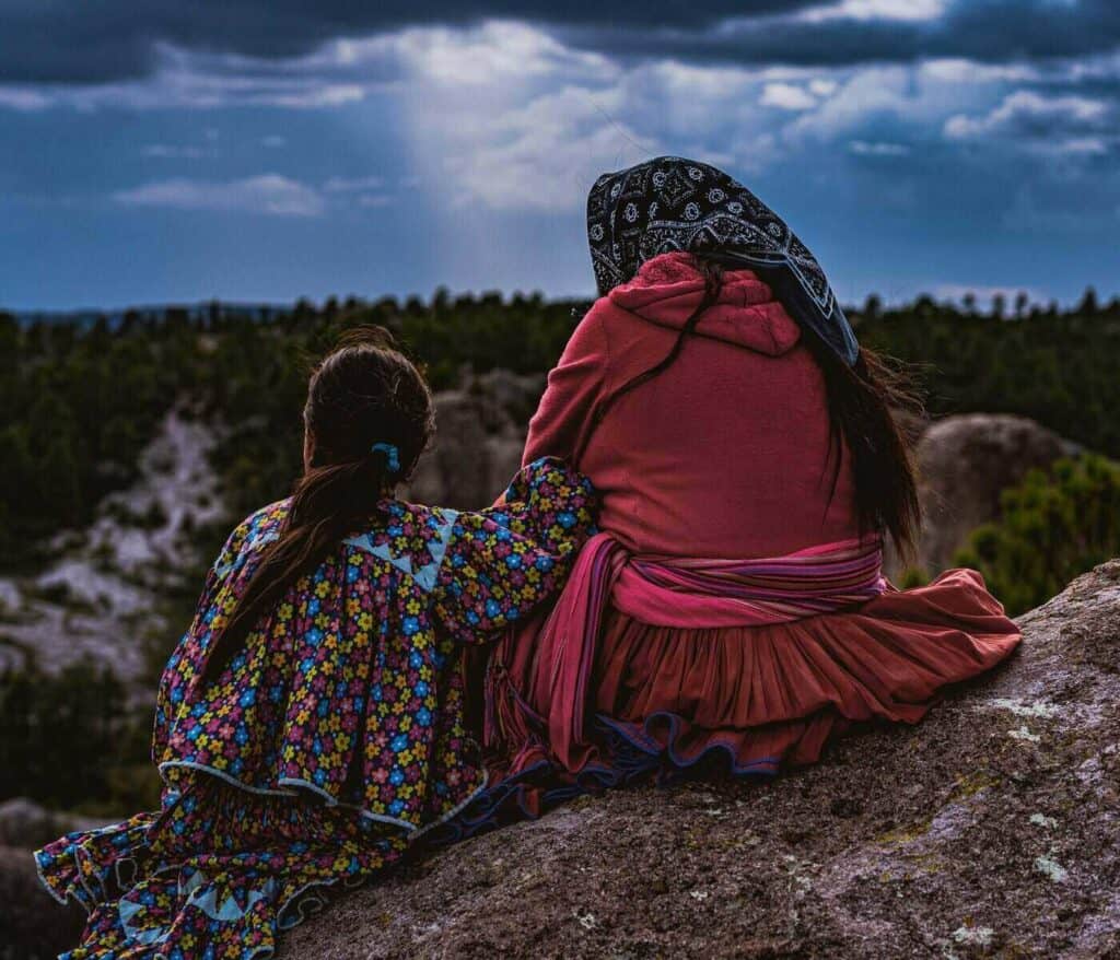 Mother and daughter from the Raramuri indigneous community sitting on a rock in Chihuahua State, Mexico