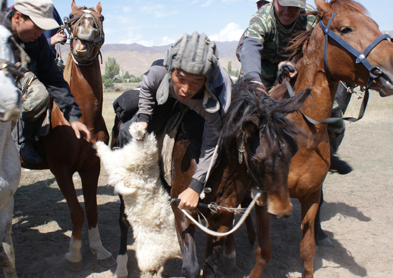 Participants fight over the dead goat in a buz kashi game, Tajikistan by Maximum Exposure Productions